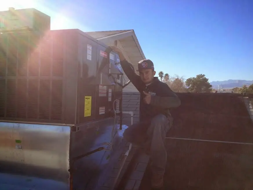 HVAC technician performing Heat Pump Repair on a rooftop unit in Tavares